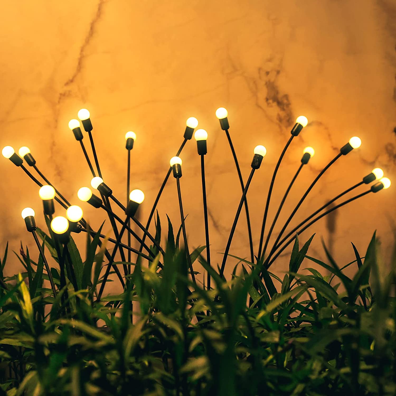 Warm LED garden stake lights with flexible stems, resembling fireflies in the grass, adding a magical glow to outdoor spaces, ideal for landscape decor, pathways, or flower beds. Durable, waterproof construction for year-round use, creating ambient lighting and a cozy, natural atmosphere in gardens, yards, and patios.