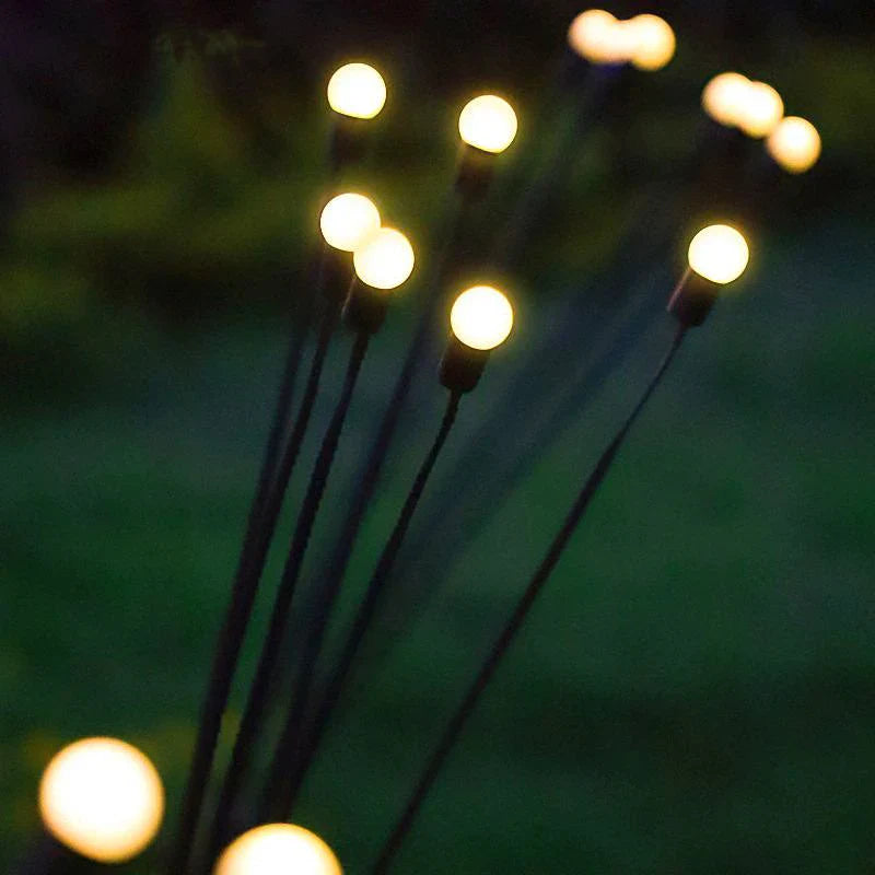 Close-up of outdoor garden lights, resembling a soft, glowing firefly effect, perfect for creating a warm, magical ambiance. These LED bulbs on tall stakes emit a gentle, solar-powered glow, ideal for enhancing gardens, pathways, and landscapes with a serene nighttime charm.